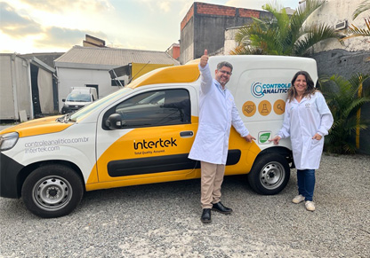 Two Intertek colleagues stand in front of one of our biofuel-powered vans. 