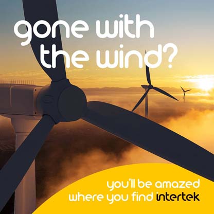 Wind turbines in a foggy setting with the sun low on the horizon